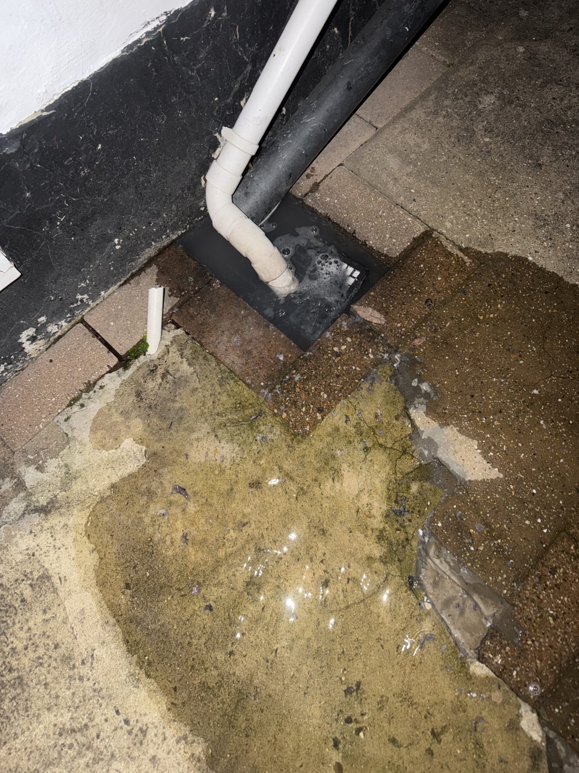 Overflowing external gully with standing water