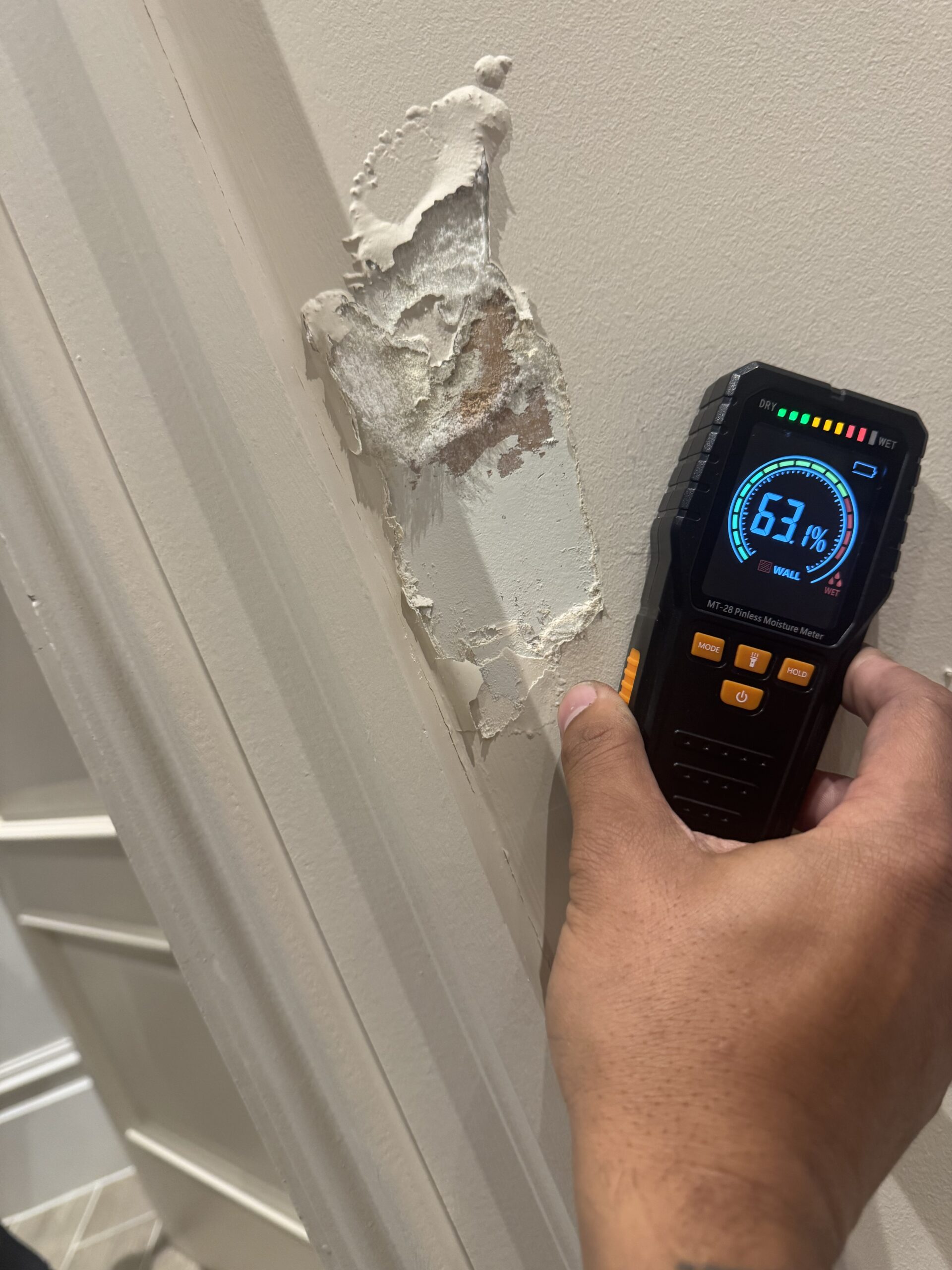 Moisture meter reading 63% on damp wall during damp survey