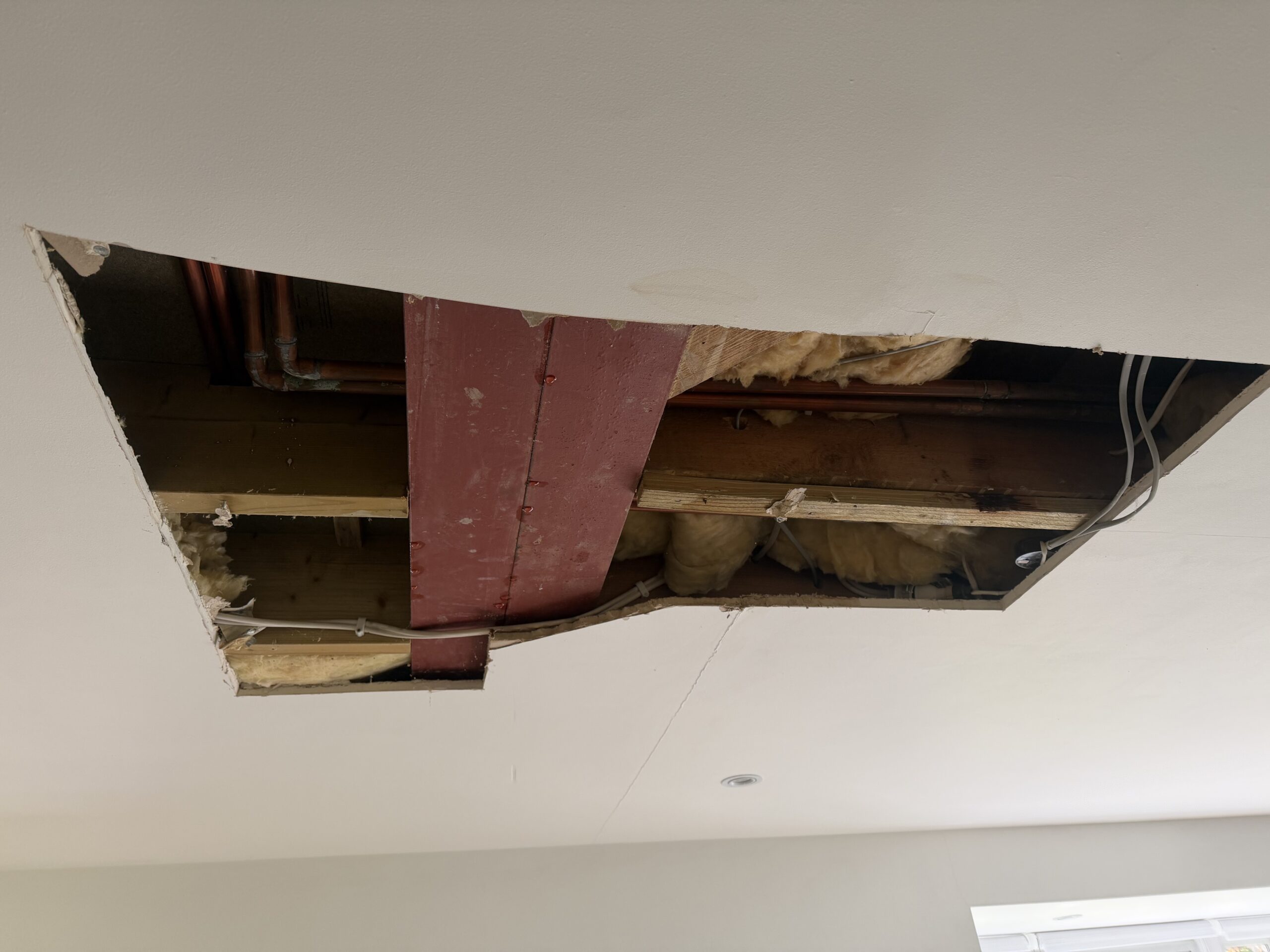 Large ceiling opening showing RSJ beam and water damage extent